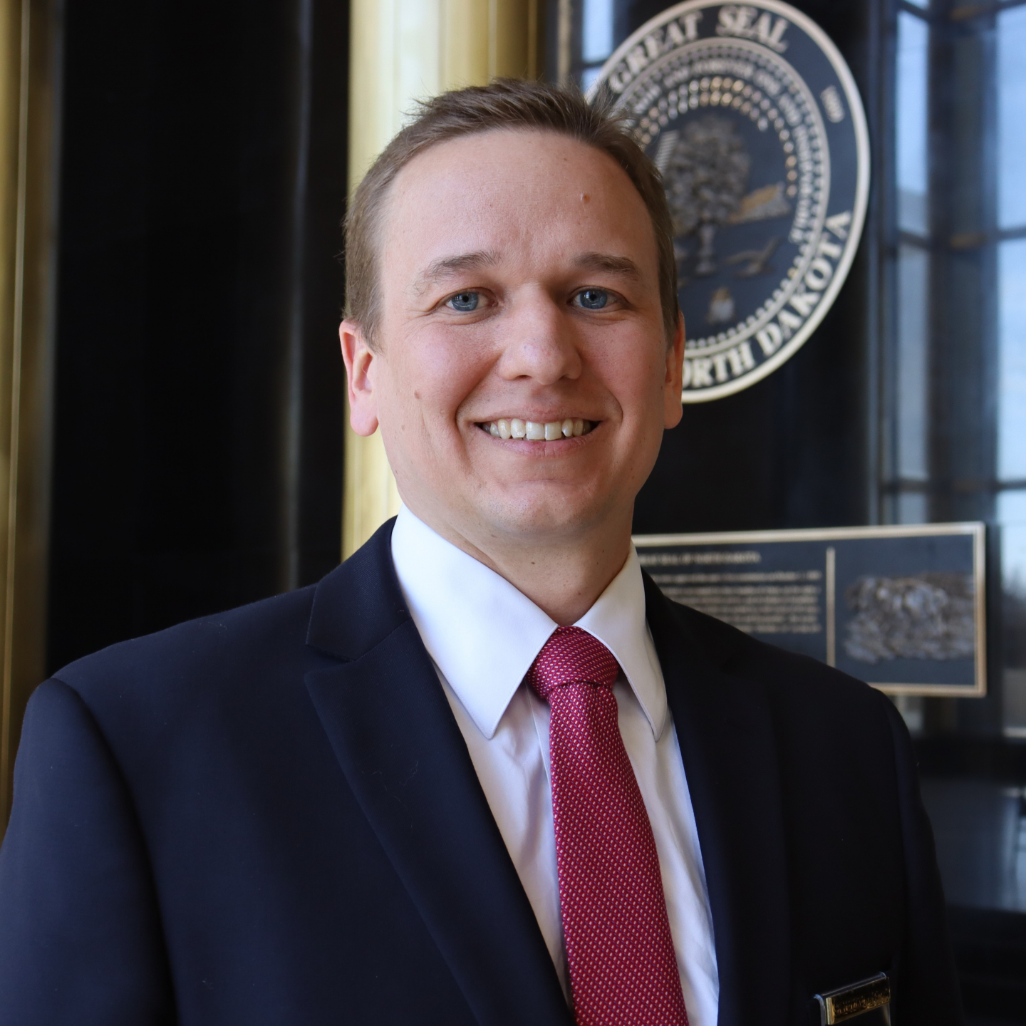 A man in a suit and tie smiling.