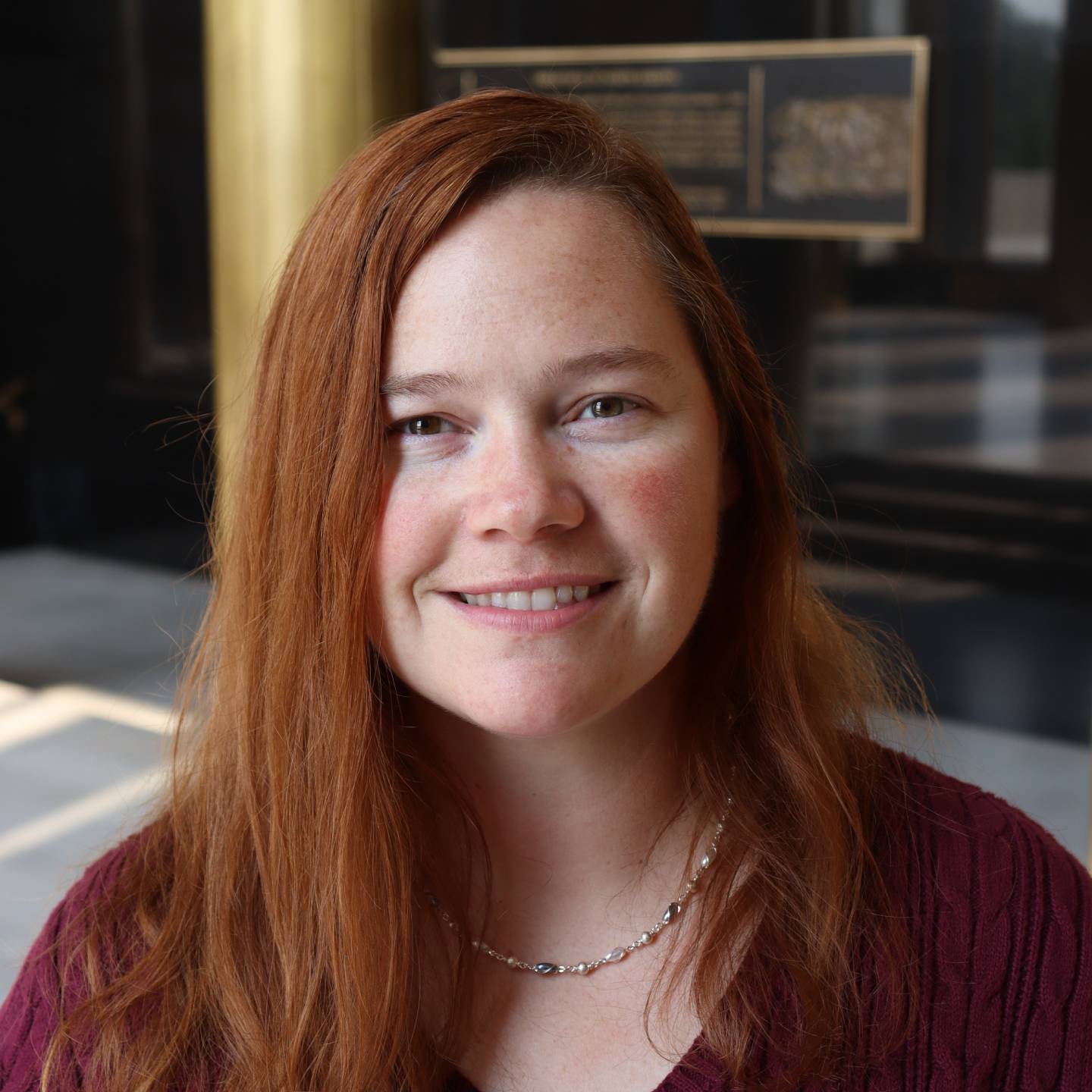 A woman with red hair smiling.